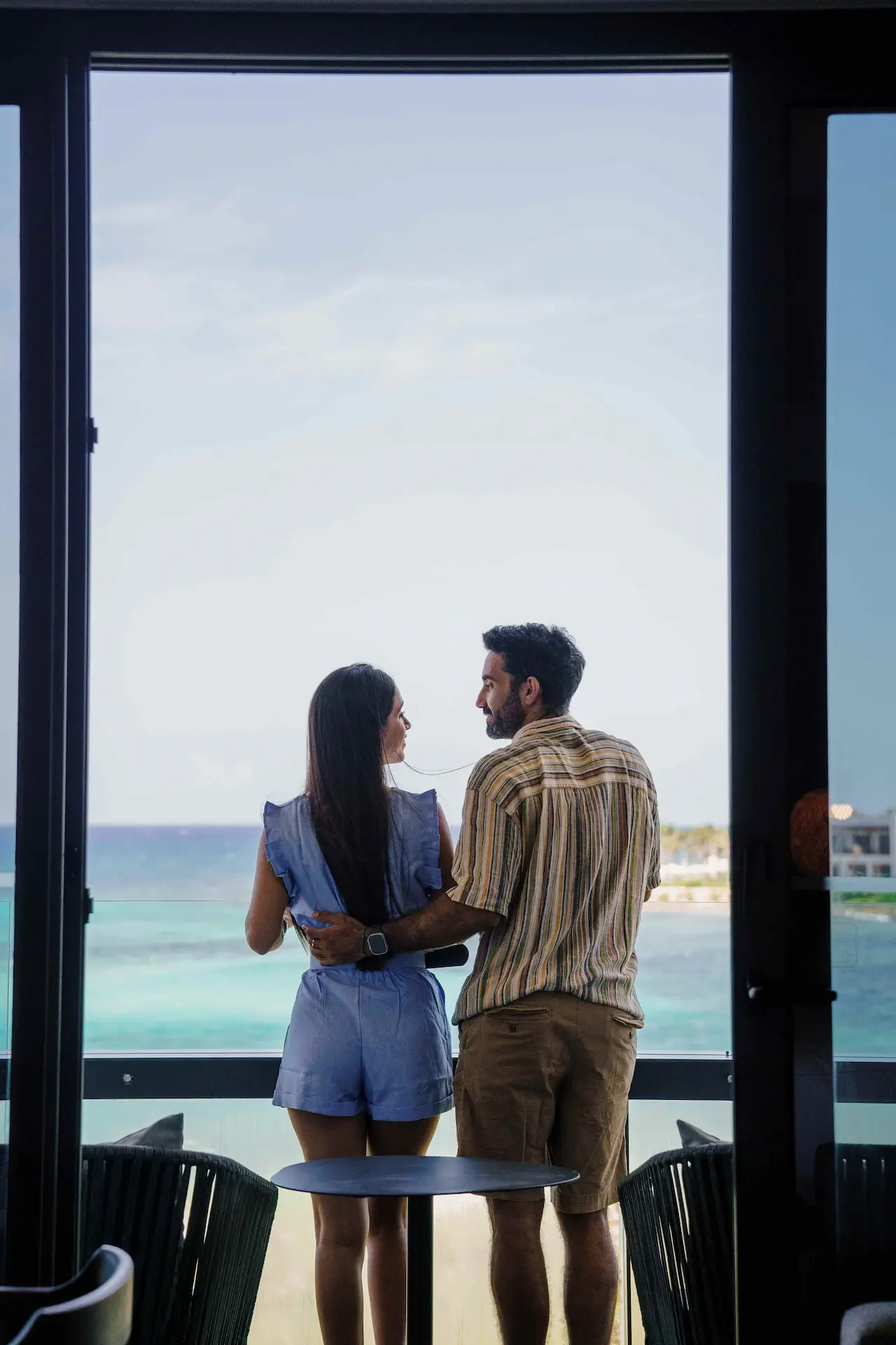 Couple on the balcony of a suite at Conrad Tulum Riviera Maya hotel.