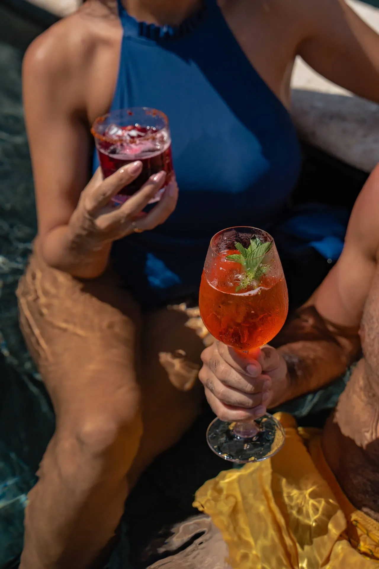 Couple enjoying cocktails by the pool at Conrad Tulum Riviera Maya hotel