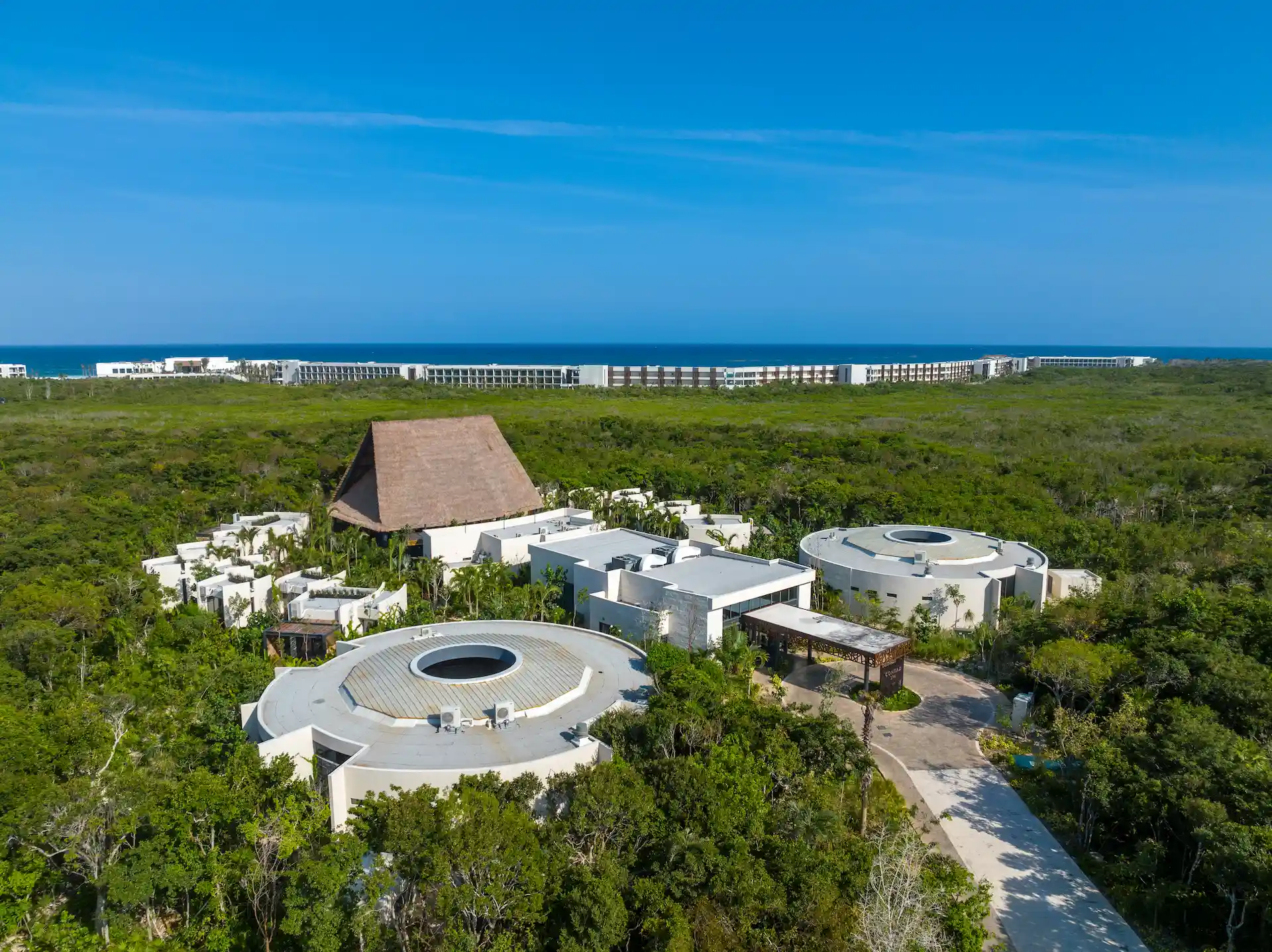 Aerial view of Conrad Tulum, surrounded by lush vegetation, offering a serene and secluded tropical retreat