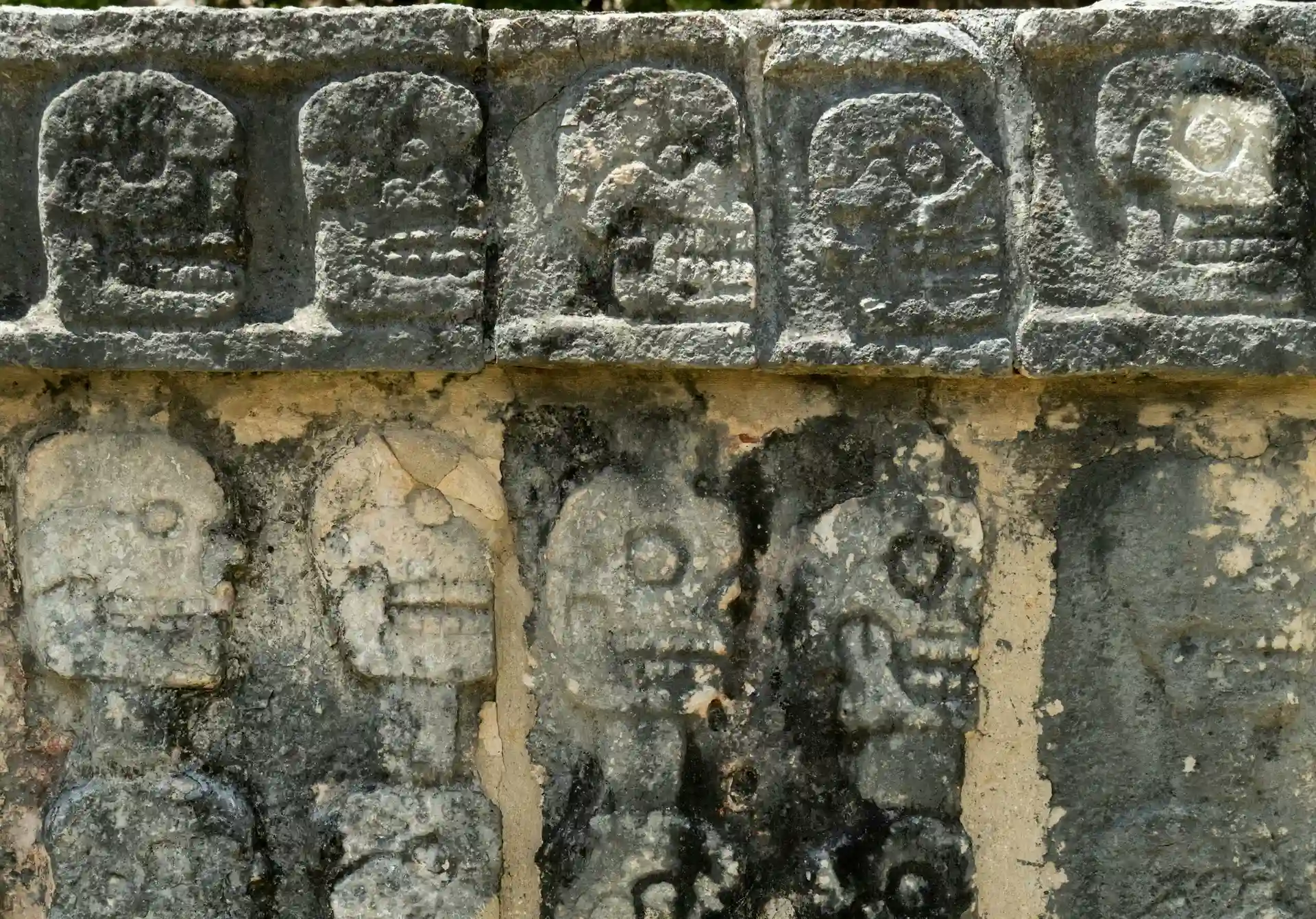 Carved Mayan figures in stone at Tulum archaeological site