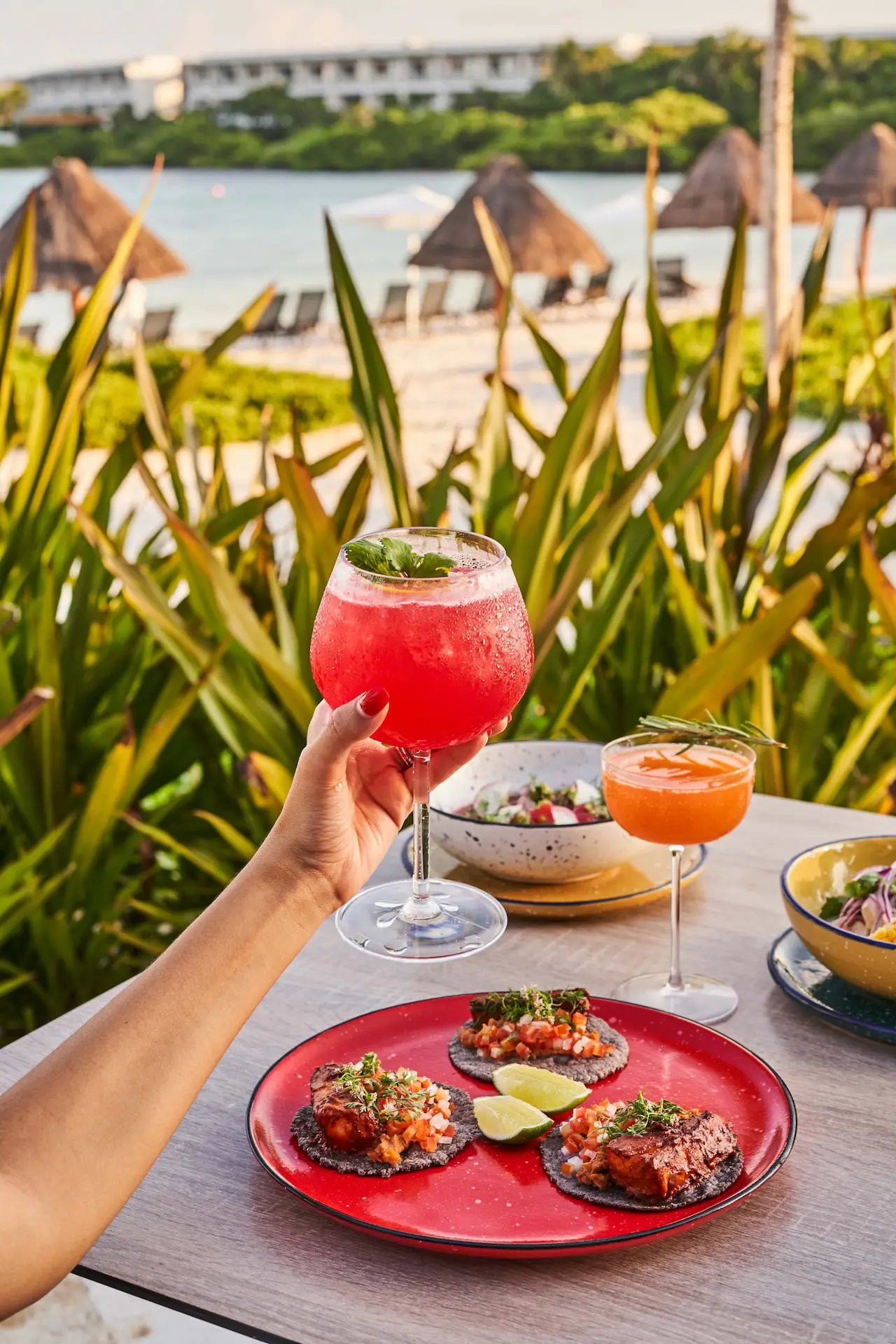 Guest showcasing her cocktail while dining at Flavors of Tulum