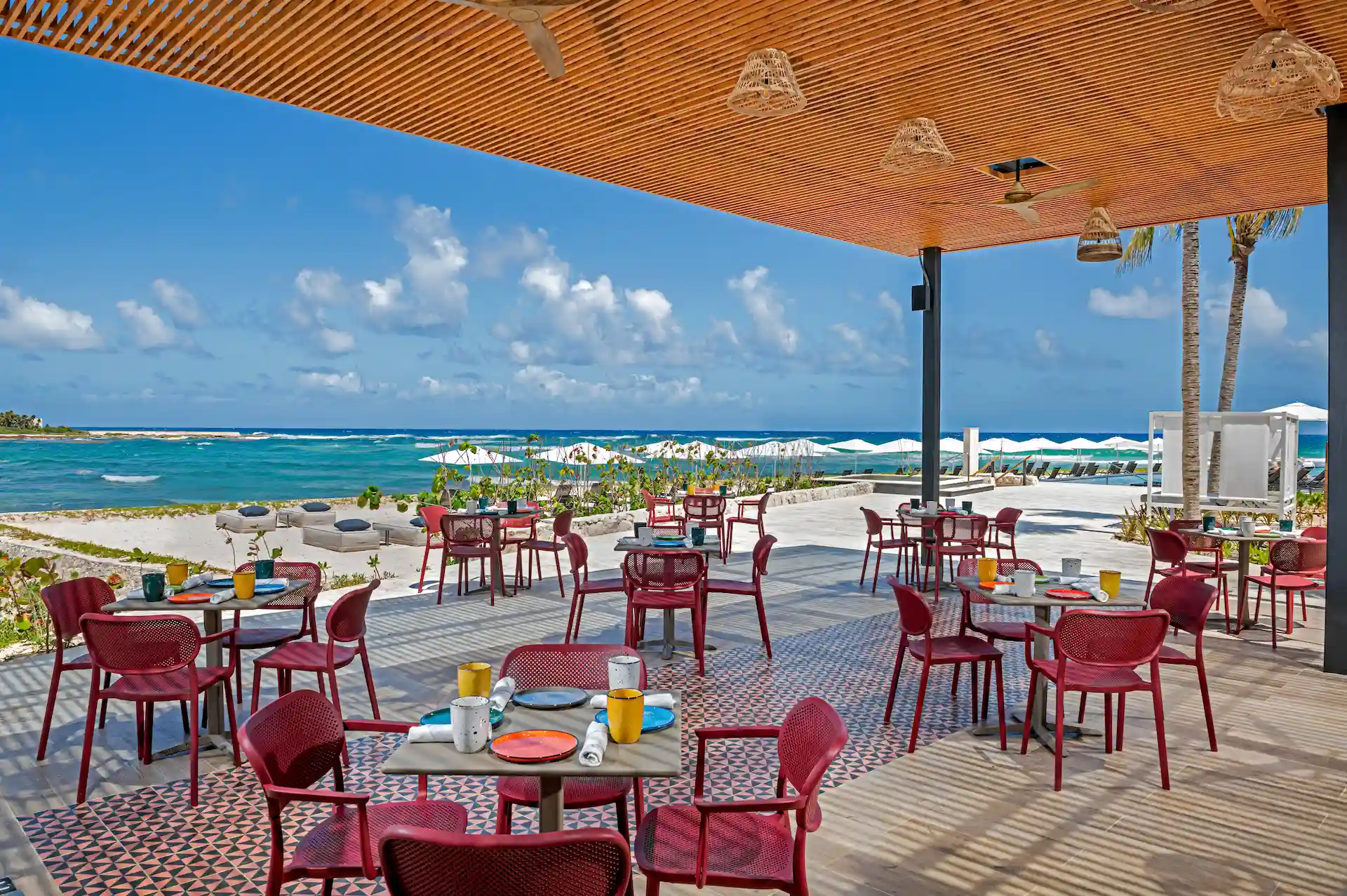 Cozy terrace at the Chiringuito beach bar in Conrad Tulum Riviera Maya adorned with tropical decor and overlooking the beach