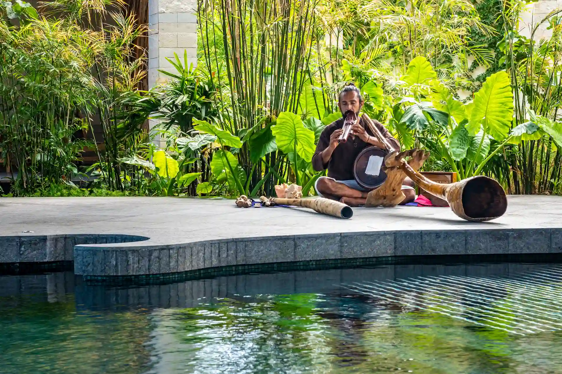 Man playing soothing instruments in the spa at Conrad Tulum, creating a calming ambiance for relaxation and wellness