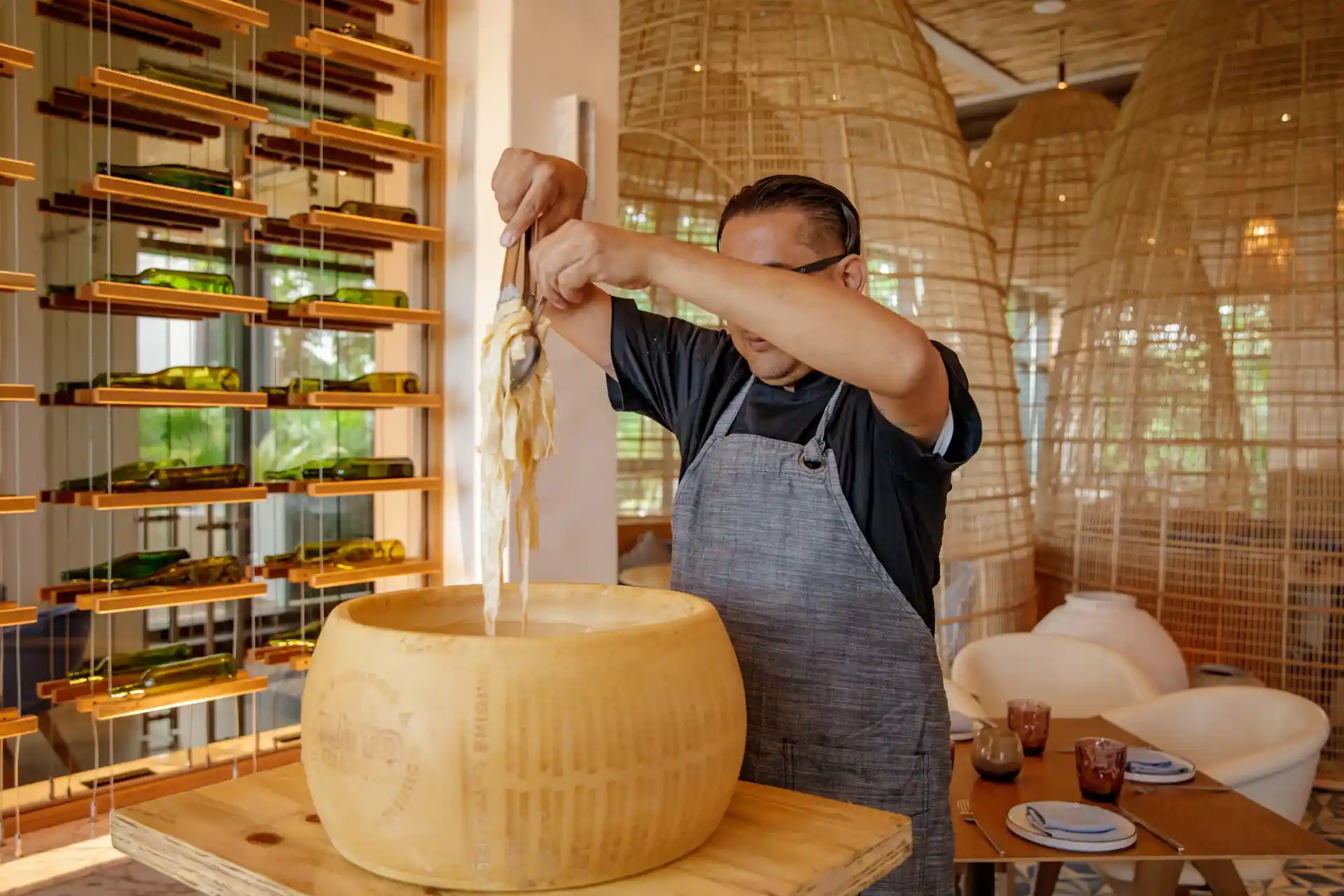 Chef preparing pasta in a cheese wheel at Maratea restaurant