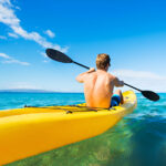 All-Inclusive Activities Man paddling a kayak through calm waters near Conrad Tulum, enjoying a scenic and peaceful adventure