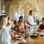 Waiter presenting a delicious meal to guests at Maratea restaurant