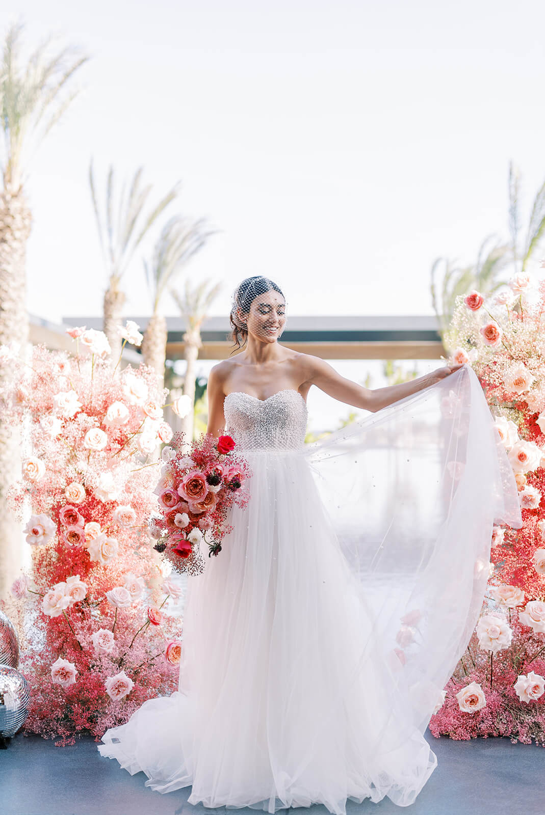 Bride posing gracefully at the altar at Conrad Tulum, holding her wedding dress with one hand