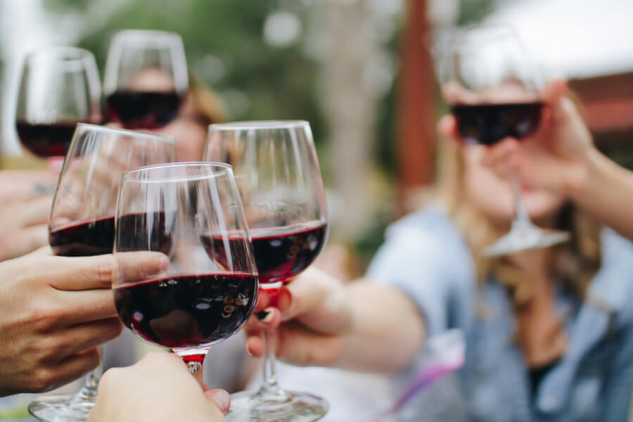 Guests raising their glasses in a toast with wine, celebrating a special occasion at Conrad Tulum