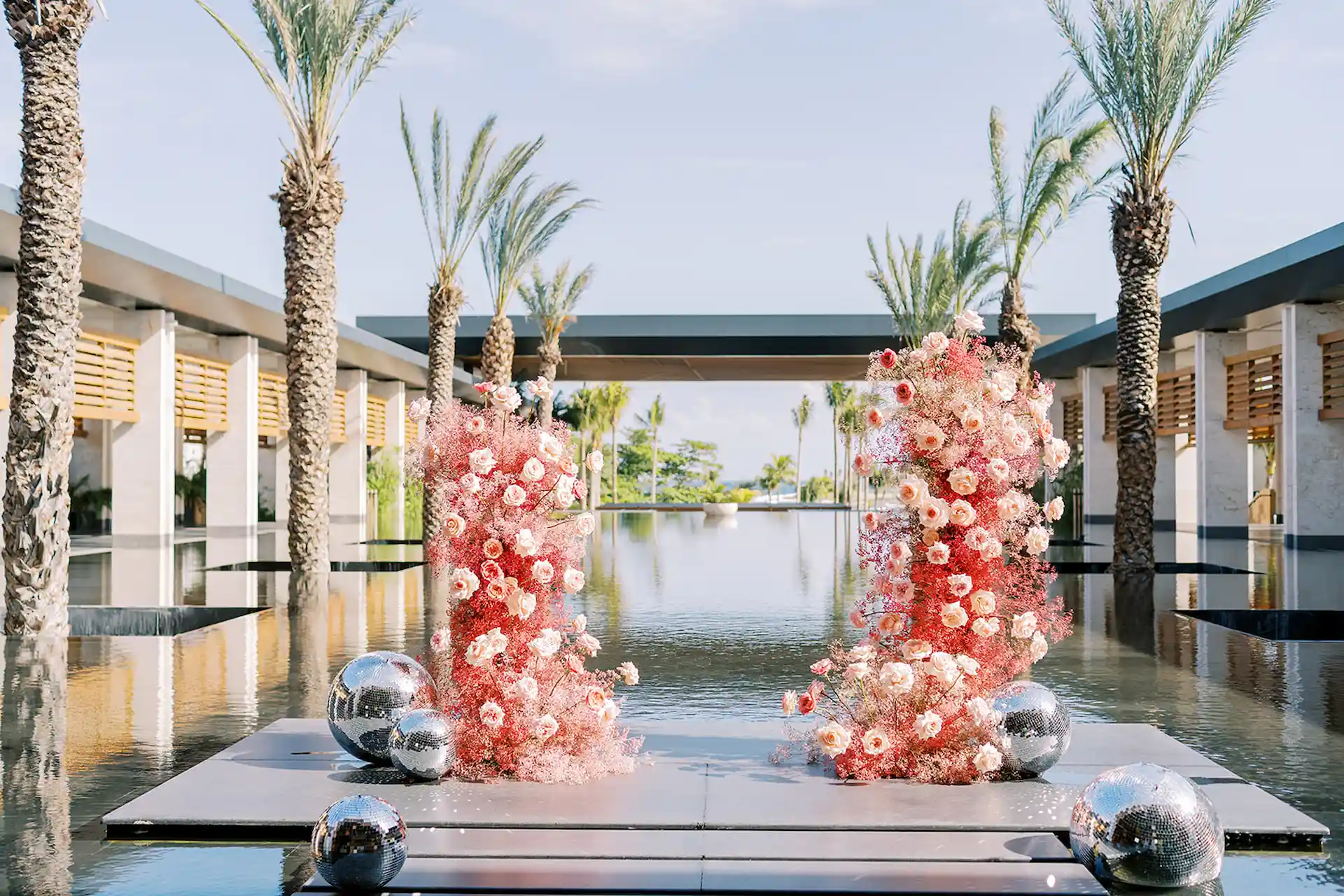 Elegant altar adorned with vibrant flowers set by the pool at Conrad Tulum for a picturesque wedding ceremony