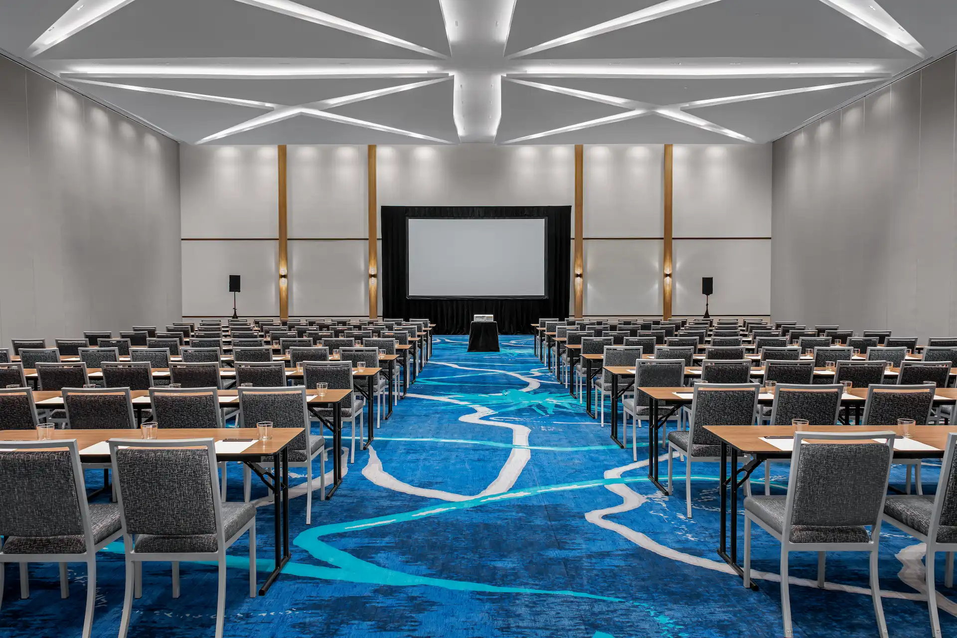 Spacious event hall at Conrad Tulum, featuring numerous chairs arranged for an upcoming event or conference