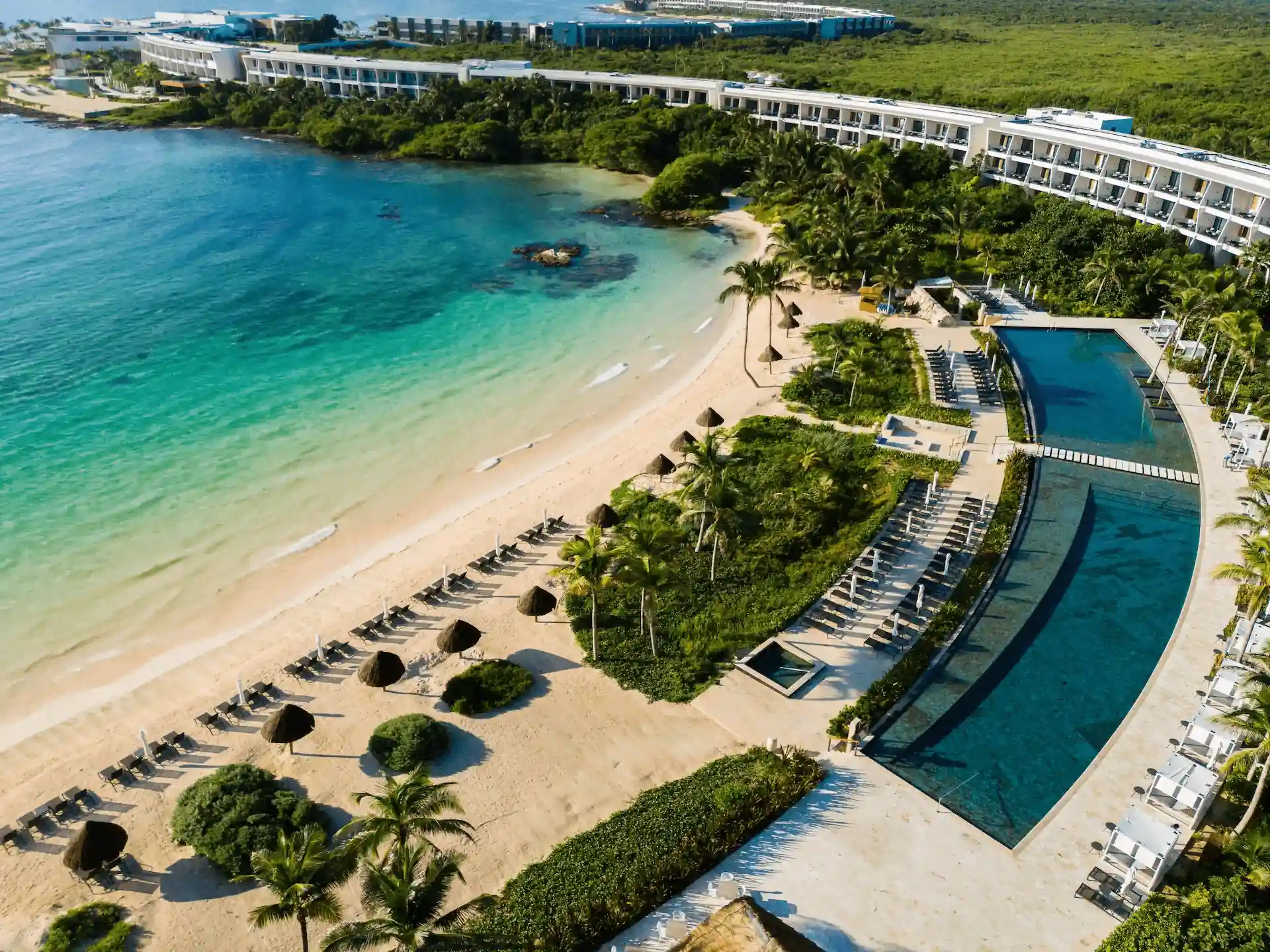 Aerial view of the private beach at Conrad Tulum, featuring soft white sands and inviting turquoise waters