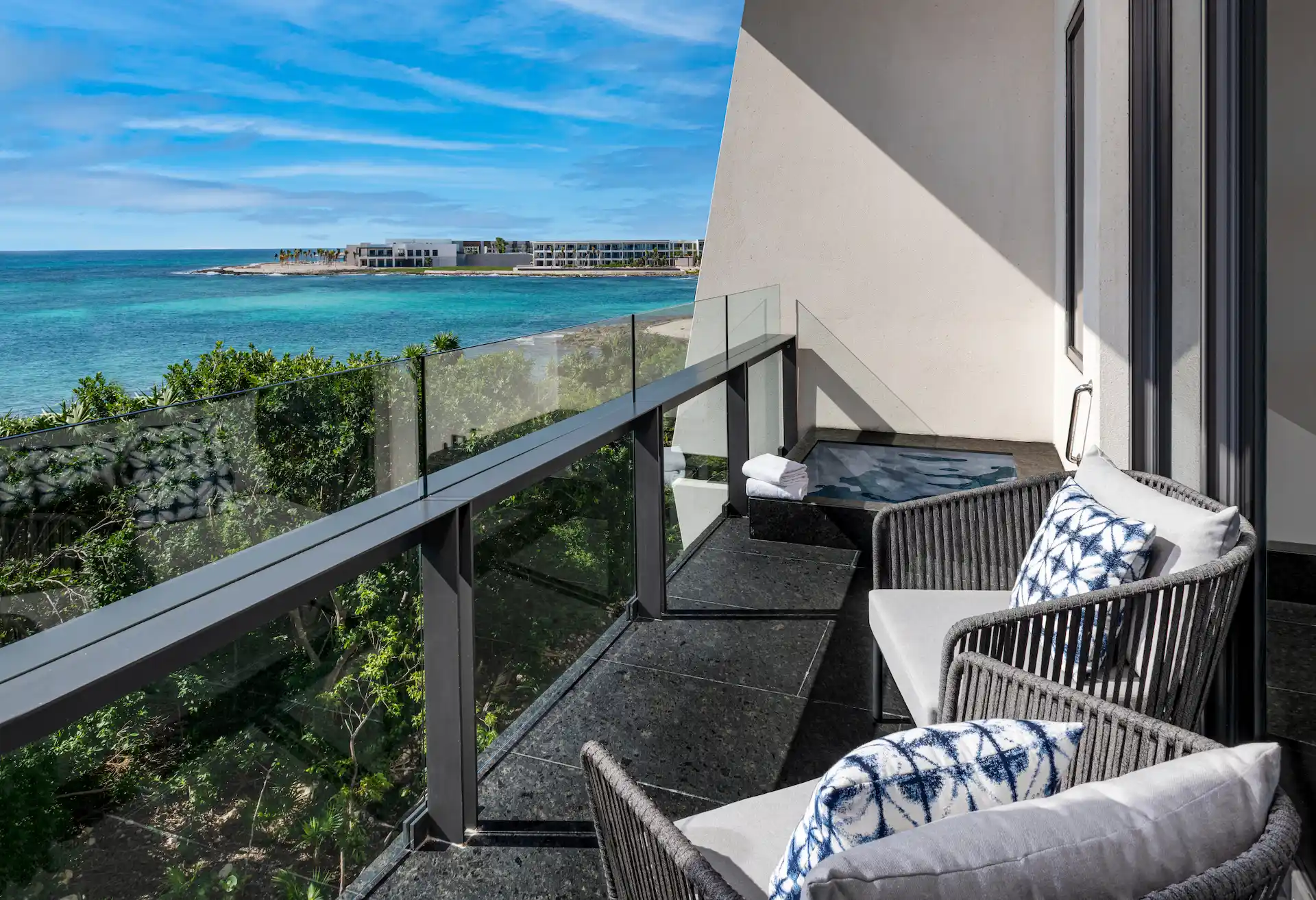 View from a hotel suite balcony at Conrad Tulum Riviera Maya overlooking the ocean and tropical surroundings.