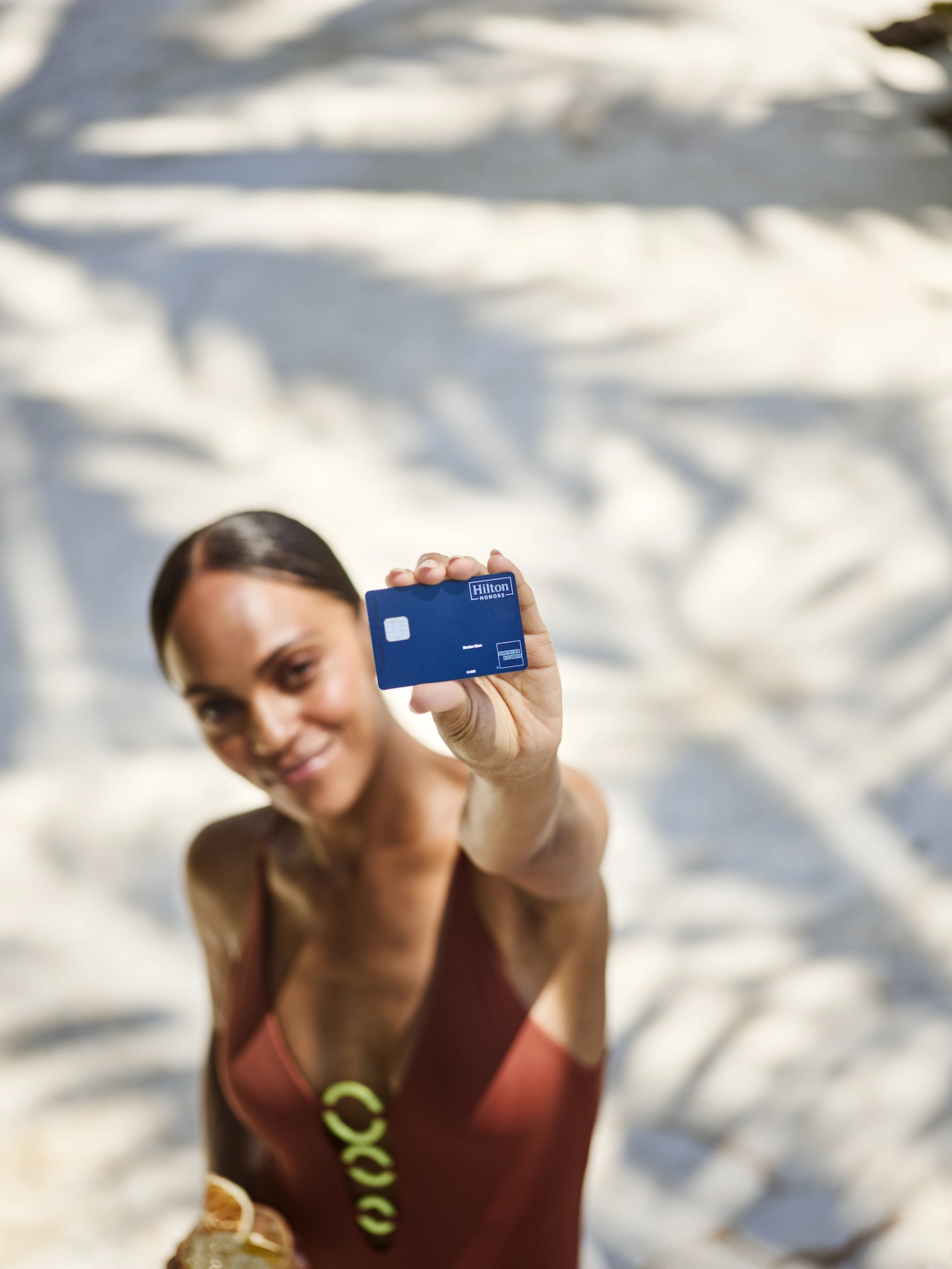 Woman proudly displaying her American Express Hilton Honors card