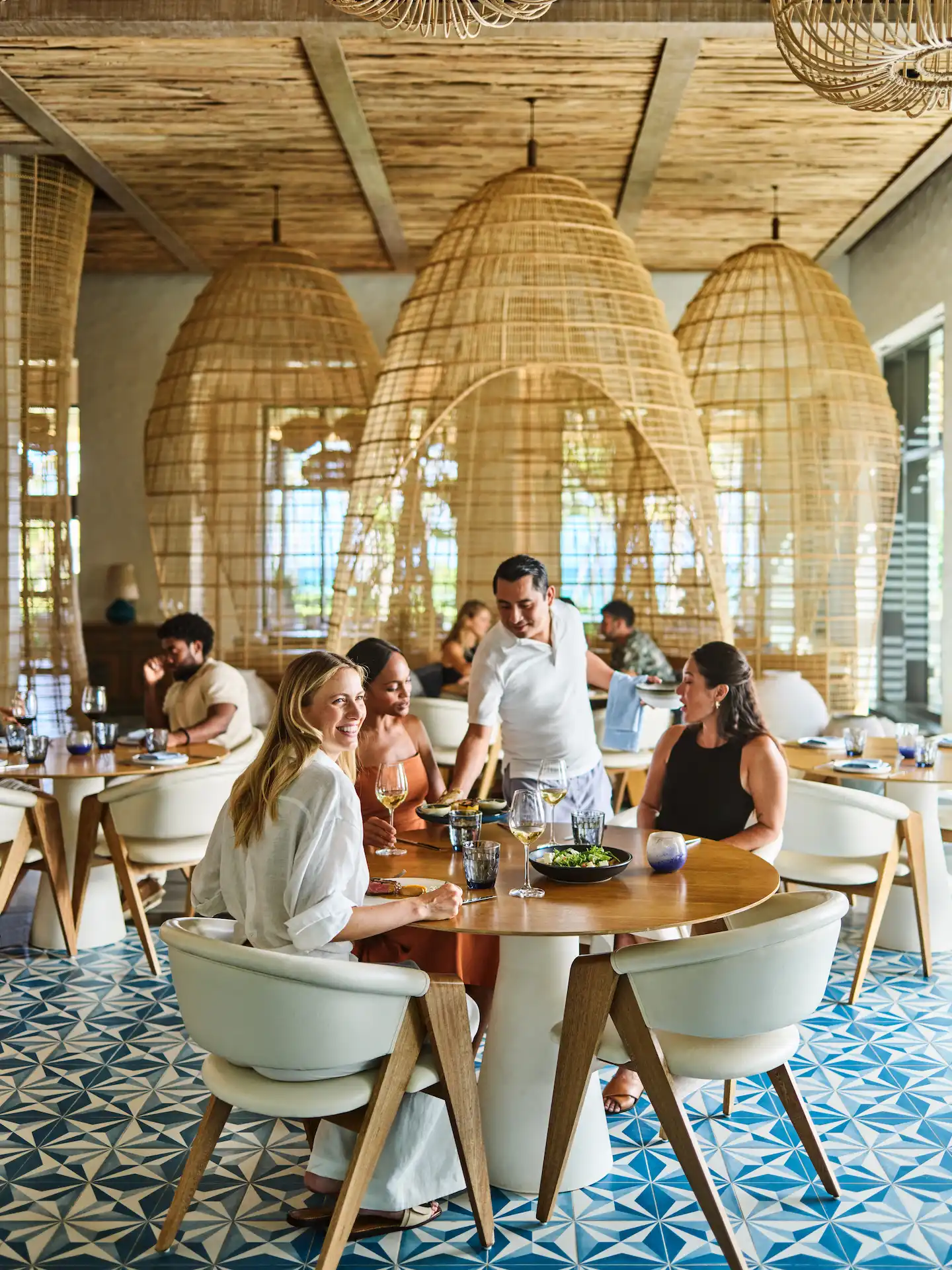 Waiter delivering a scrumptious dish to guests at the Maratea restaurant in Conrad Tulum