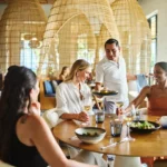 Waiter serving a delightful meal to guests at the Maratea restaurant in Conrad Tulum