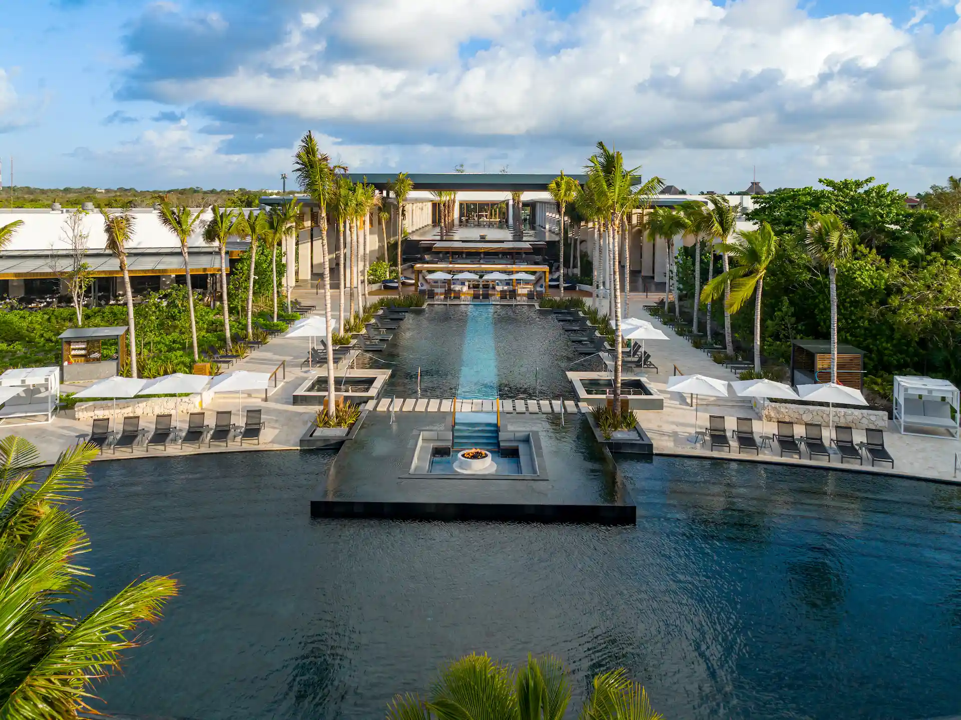 Aerial view of the Ultramar pool surrounded by palm trees, showcasing a tropical paradise setting