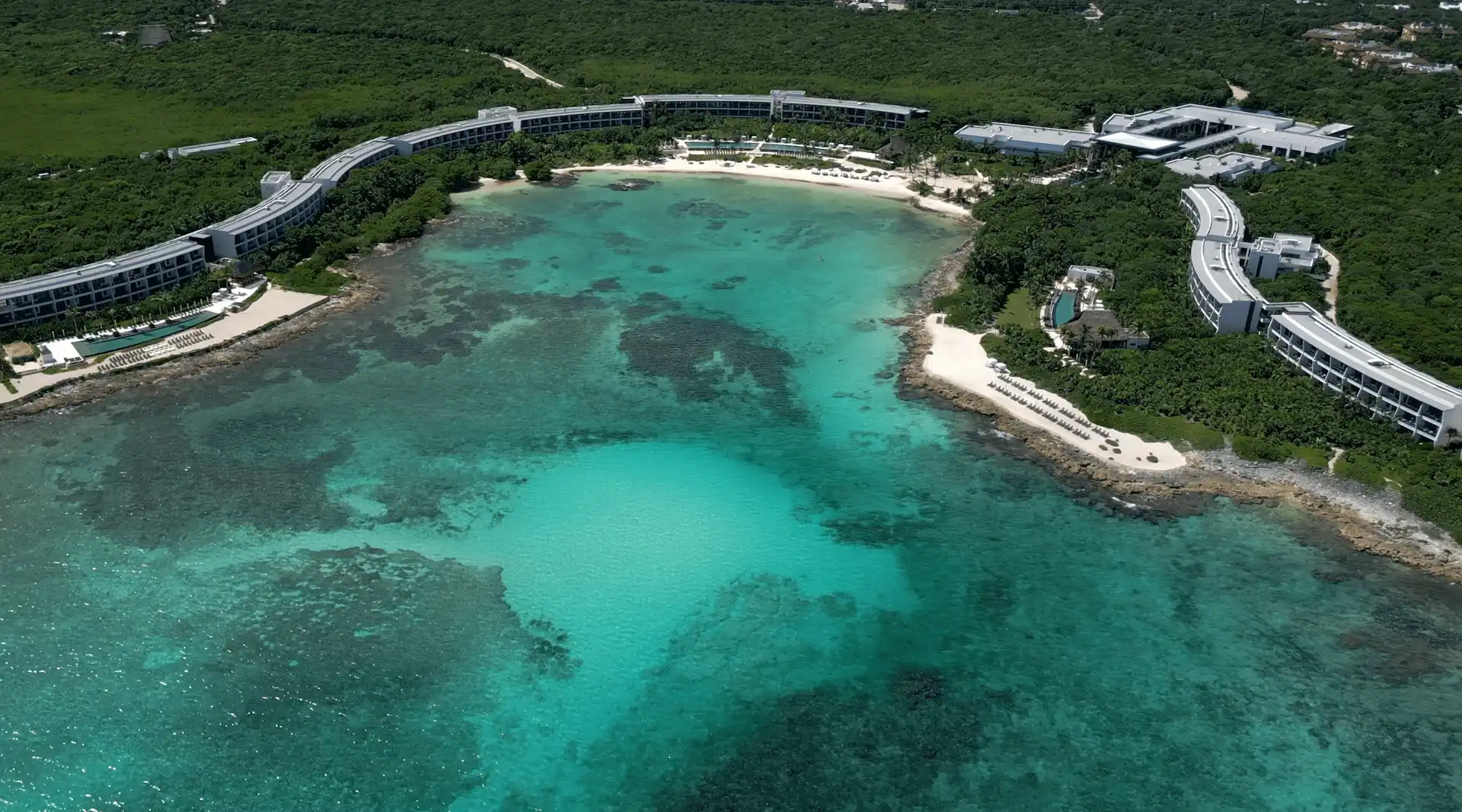 Aerial view of Conrad Tulum resort, featuring crystal-clear turquoise waters and a pristine private beach