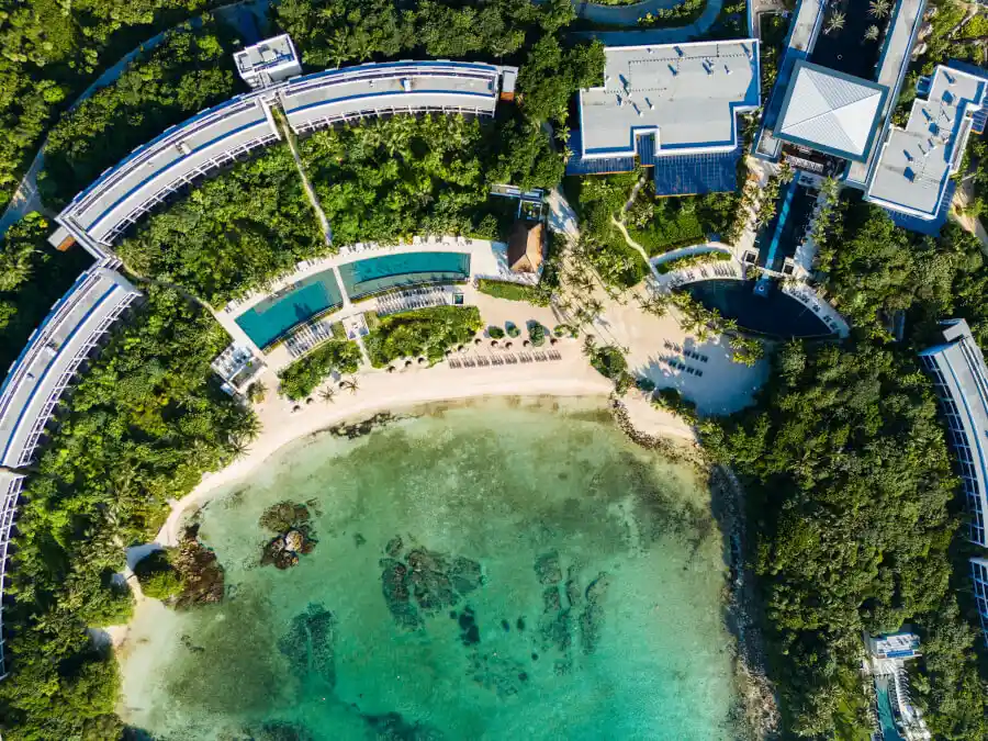 Aerial view of Conrad Tulum Riviera Maya with lush greenery, private beach, and pools.